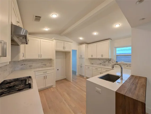 a kitchen that has a sink a stove and a refrigerator
