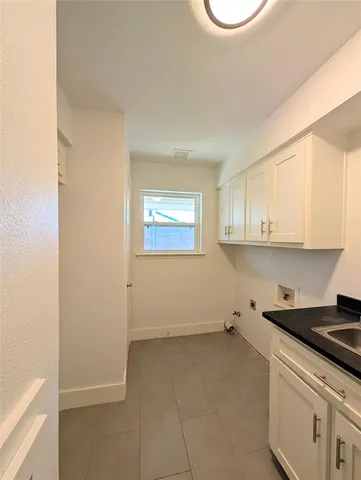 a room with a white cabinets and a sink