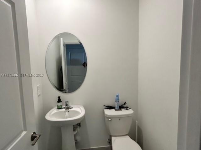 11914 Southwest 241st Street Homestead, FL 33032 - Photo 22 of 25 a bathroom with a toilet sink and mirror
