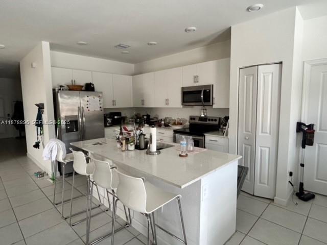 11914 Southwest 241st Street Homestead, FL 33032 - Photo 4 of 25 a kitchen with stainless steel appliances a stove a sink a microwave a refrigerator and cabinets
