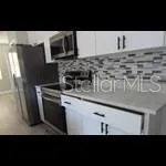 a kitchen with a sink a microwave a stove and refrigerator