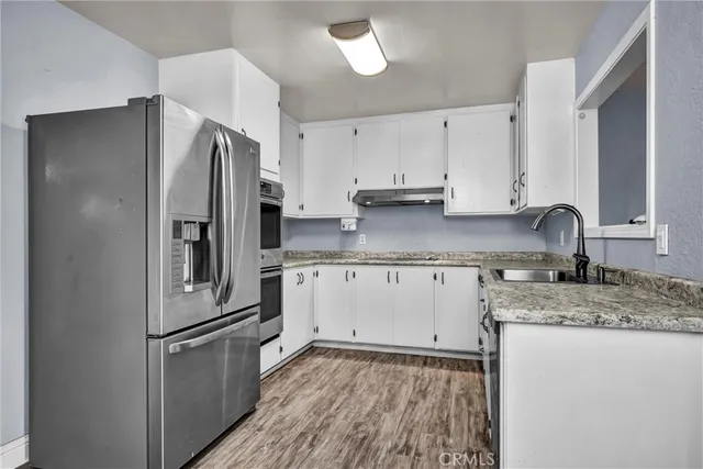 a kitchen with stainless steel appliances granite countertop a refrigerator sink and cabinets