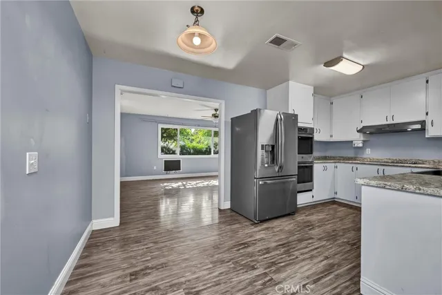 a kitchen with a refrigerator and a stove top oven