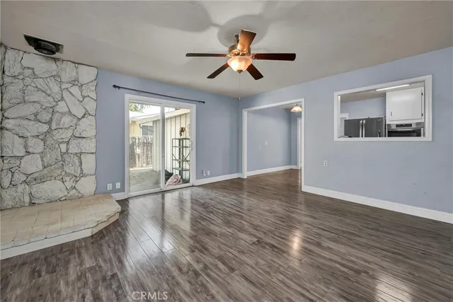 a view of an empty room with window and wooden floor