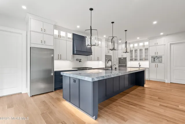 a kitchen with kitchen island granite countertop a large counter top stainless steel appliances and cabinets