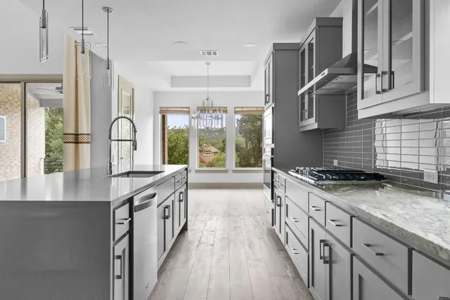 a kitchen with stainless steel appliances granite countertop a stove and a sink