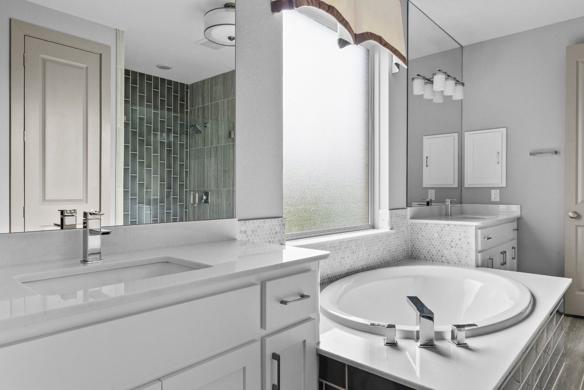 8108 Turning Leaf Circle Lago Vista, TX 78645 - Photo 18 of 40 The primary bath is all luxury—dual vanities, spa tub, and clean modern lines throughout.