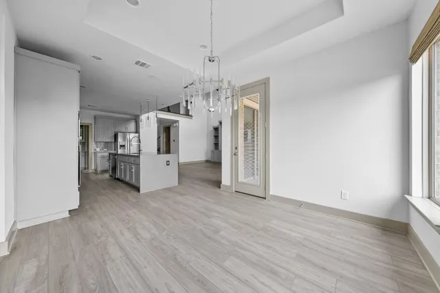 a view of a kitchen with a sink and dishwasher a refrigerator with wooden floor