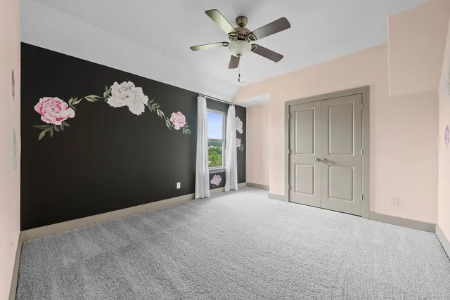 a view of an empty room with a chandelier fan