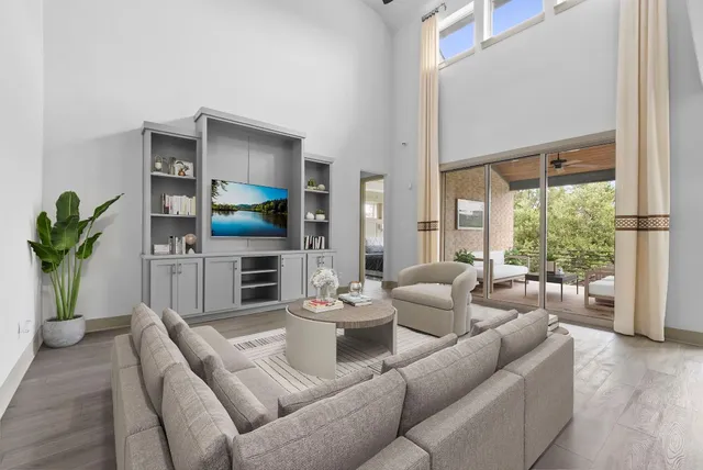 a living room with furniture a large window with kitchen view