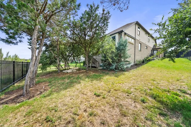 a view of a yard in front of a house with large tree