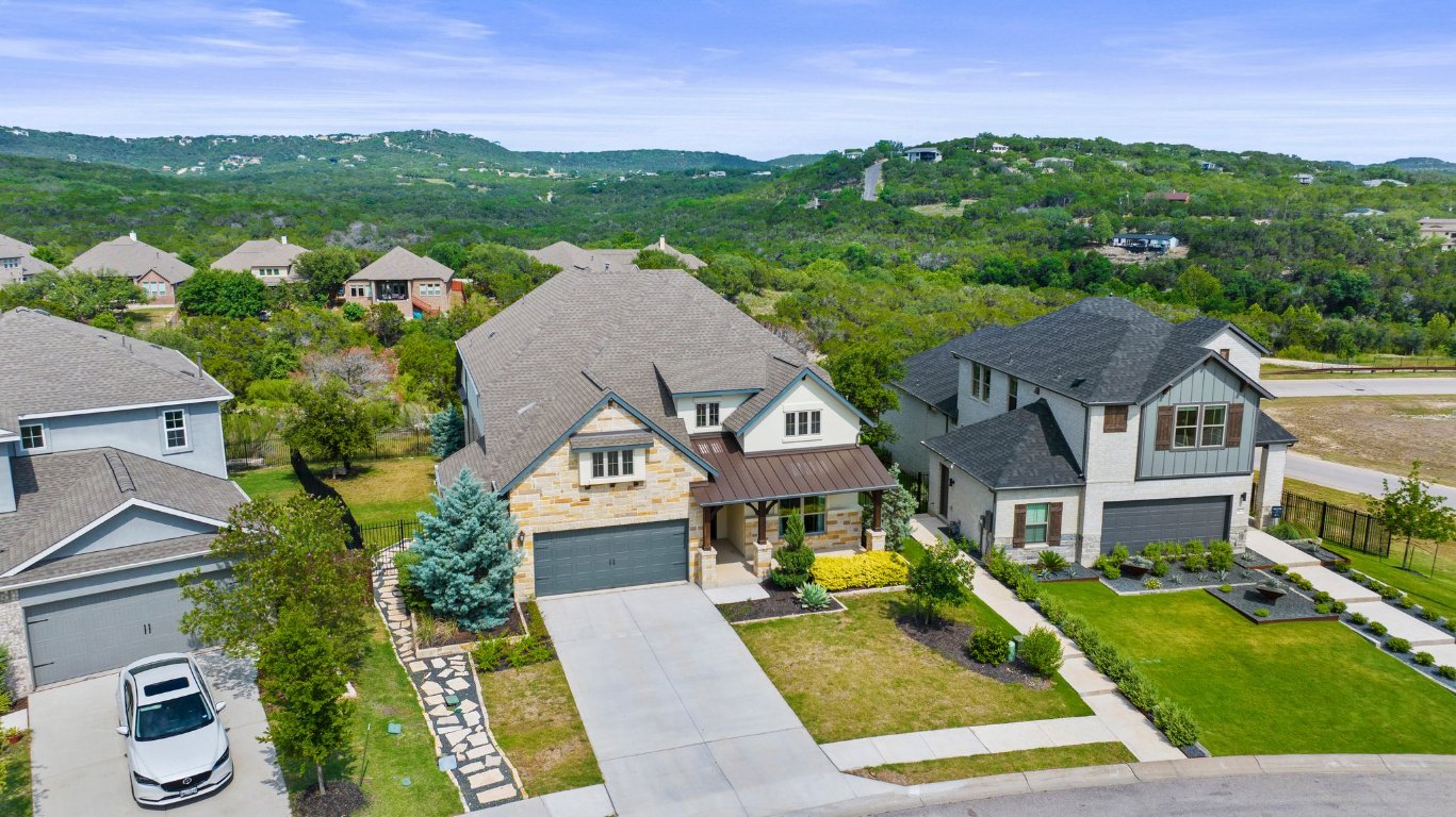 8108 Turning Leaf Circle Lago Vista, TX 78645 - Photo 8 of 40 The exterior shines with stonework, gabled dormers, and mature landscaping, along with wrought iron fencing and direct access to the community’s walking trail.