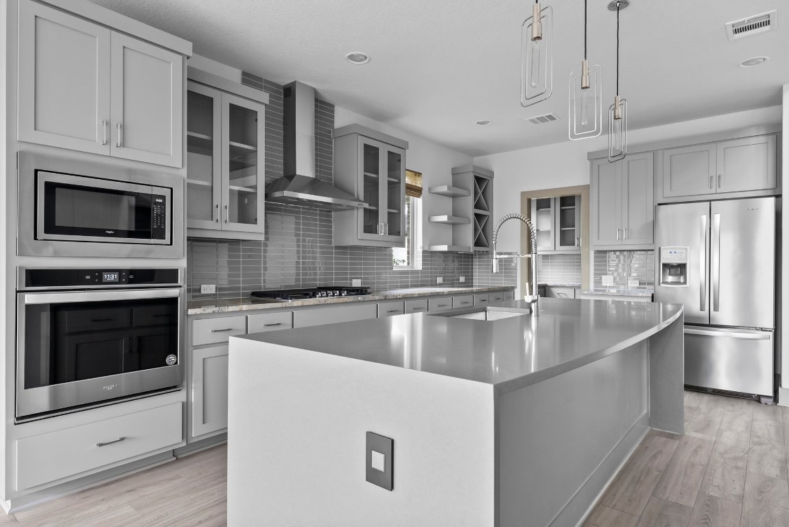 8108 Turning Leaf Circle Lago Vista, TX 78645 - Photo 9 of 40 Waterfall-edge quartz, upgraded fixtures, and pro-style appliances make this island the heart of the home.