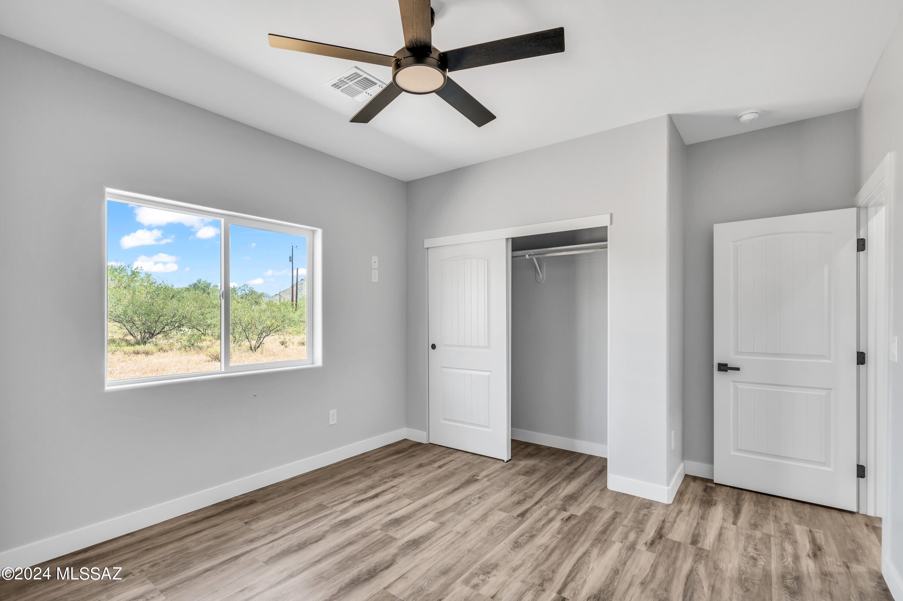 1849 Circulo Mexicali Rio Rico, AZ 85648 - Photo 17 of 29 a view of empty room with wooden floor and fan