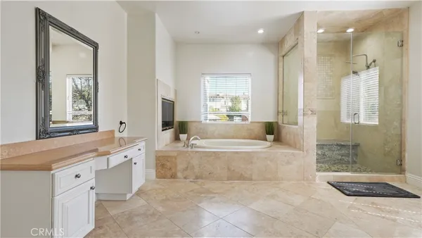 a large spacious bathroom with a granite countertop tub shower and mirror