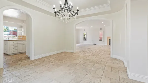 a view of a hallway with chandelier and glass door