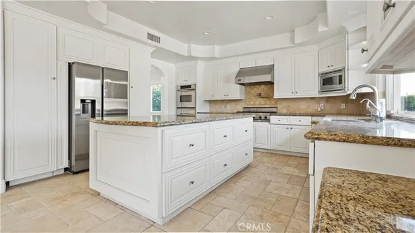 a kitchen with granite countertop a sink and cabinets