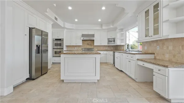 a kitchen with white cabinets and white appliances