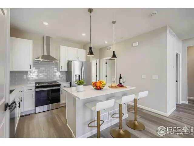 a kitchen with kitchen island a stove a table a sink refrigerator and cabinets