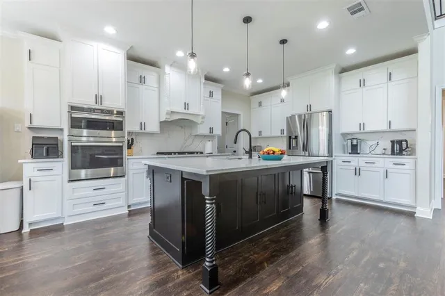 a kitchen with a white wooden cabinets and white stainless steel appliances