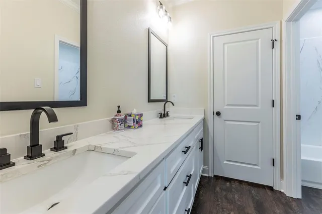 a bathroom with a double vanity sink and a mirror