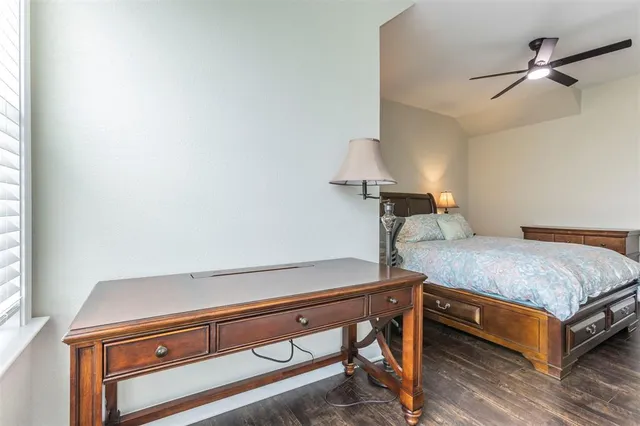 a bedroom with a bed and a table with wooden floor