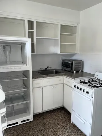a kitchen with cabinets appliances and a window