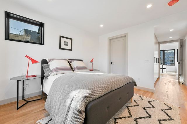 a spacious bedroom with a bed and a lamp on table