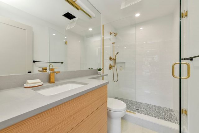 a bathroom with a sink a toilet and shower