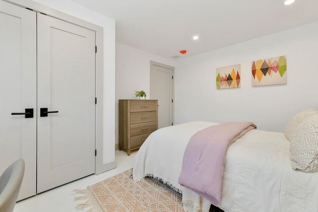 a bedroom with a bed and a painting on the wall