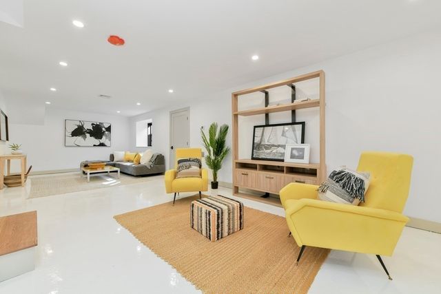 a living room with furniture kitchen view and a large window