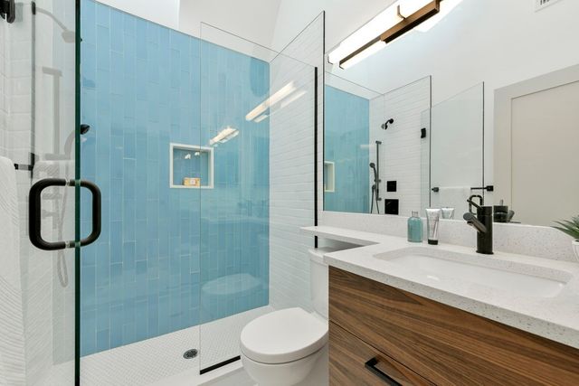 a bathroom with a sink a toilet and shower