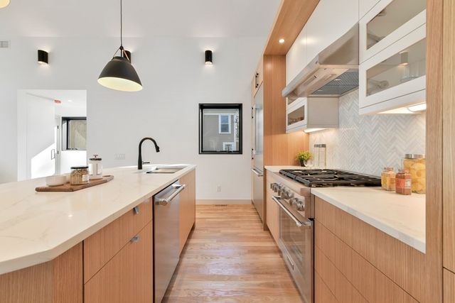 a kitchen with stainless steel appliances a sink stove and cabinets
