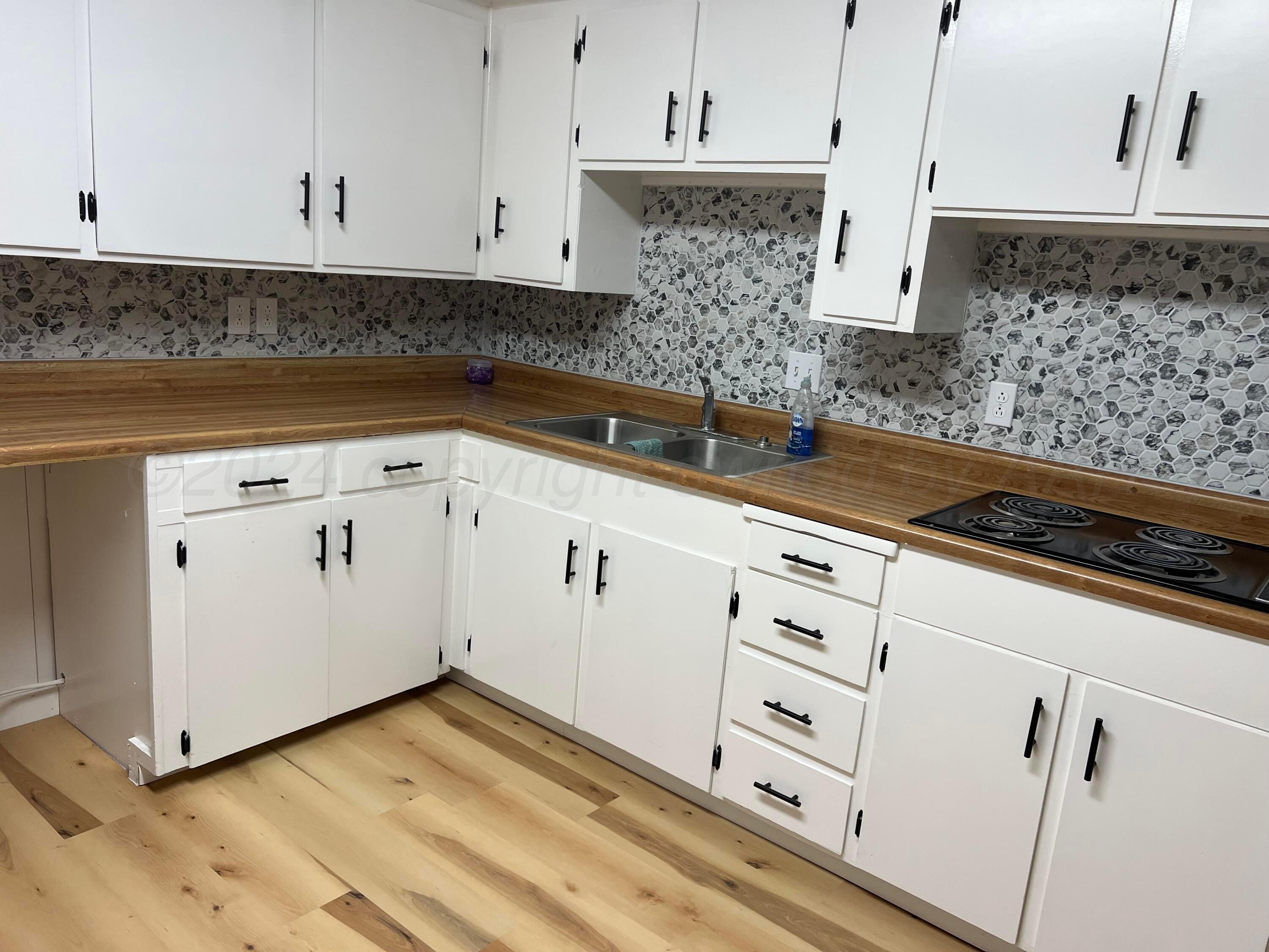 403 Cherry Street Claude, TX 79019 - Photo 9 of 110 a kitchen with granite countertop white cabinets and white appliances