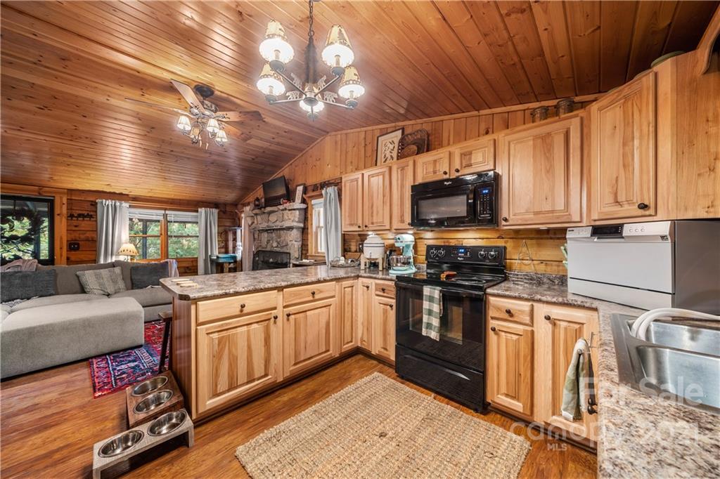 146 Spring Drive Maggie Valley, NC 28751 - Photo 7 of 36 a kitchen with stainless steel appliances granite countertop a sink a stove and cabinets