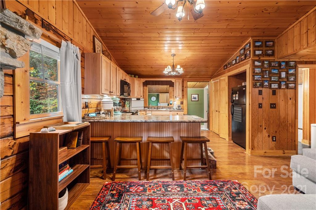 146 Spring Drive Maggie Valley, NC 28751 - Photo 10 of 36 a dining room with stainless steel appliances kitchen island granite countertop a table chairs and a chandelier