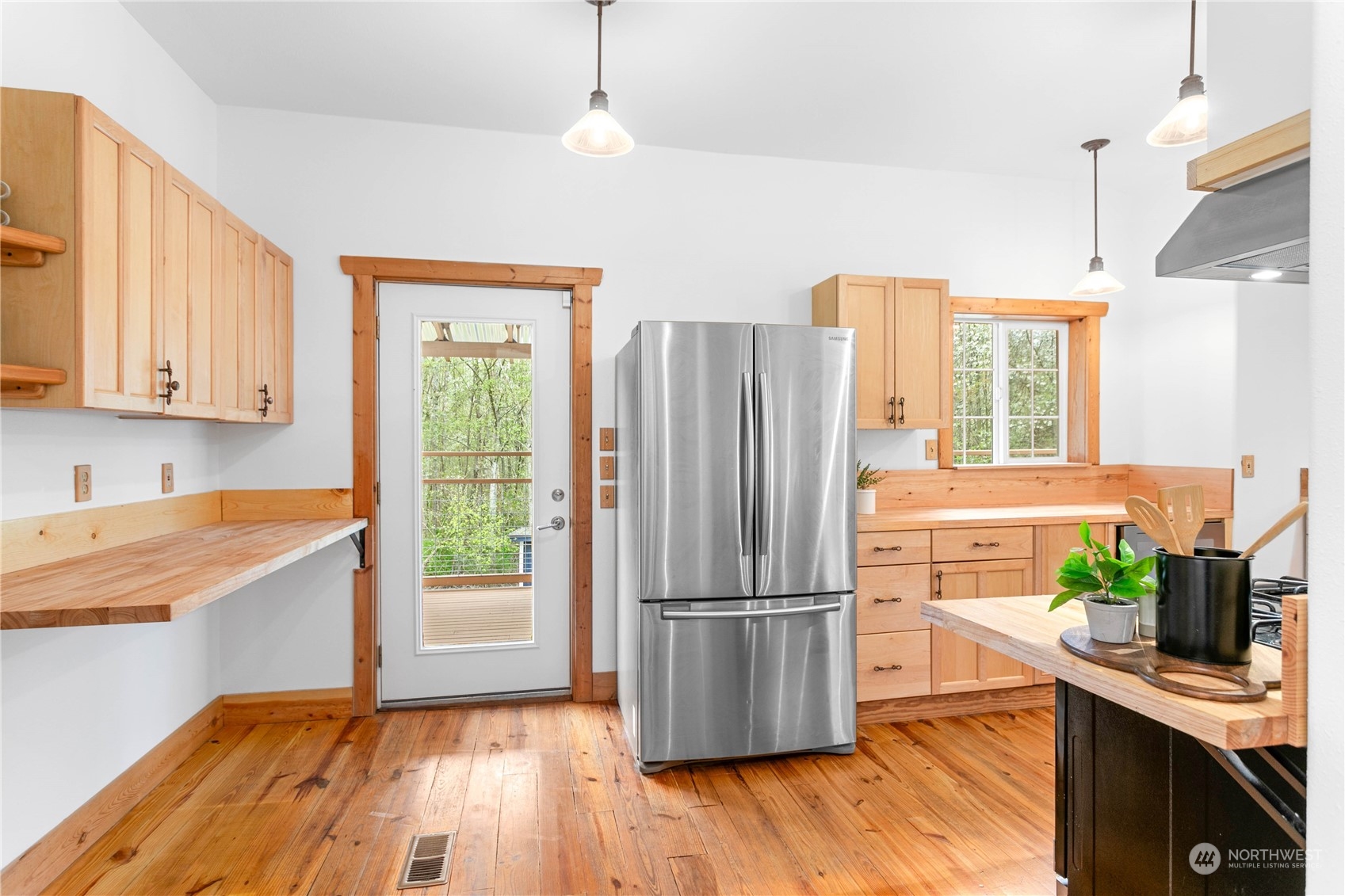 3900 Bay Road Ferndale, WA 98248 - Photo 7 of 40 a kitchen with stainless steel appliances granite countertop a refrigerator a microwave oven a sink with wooden floors and cabinets