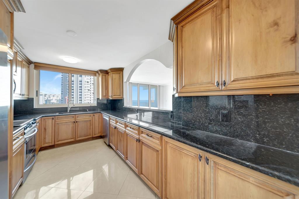 1360 South Ocean Boulevard, Unit 905 Pompano Beach, FL 33062 - Photo 12 of 57 a kitchen with granite countertop a sink and white cabinets
