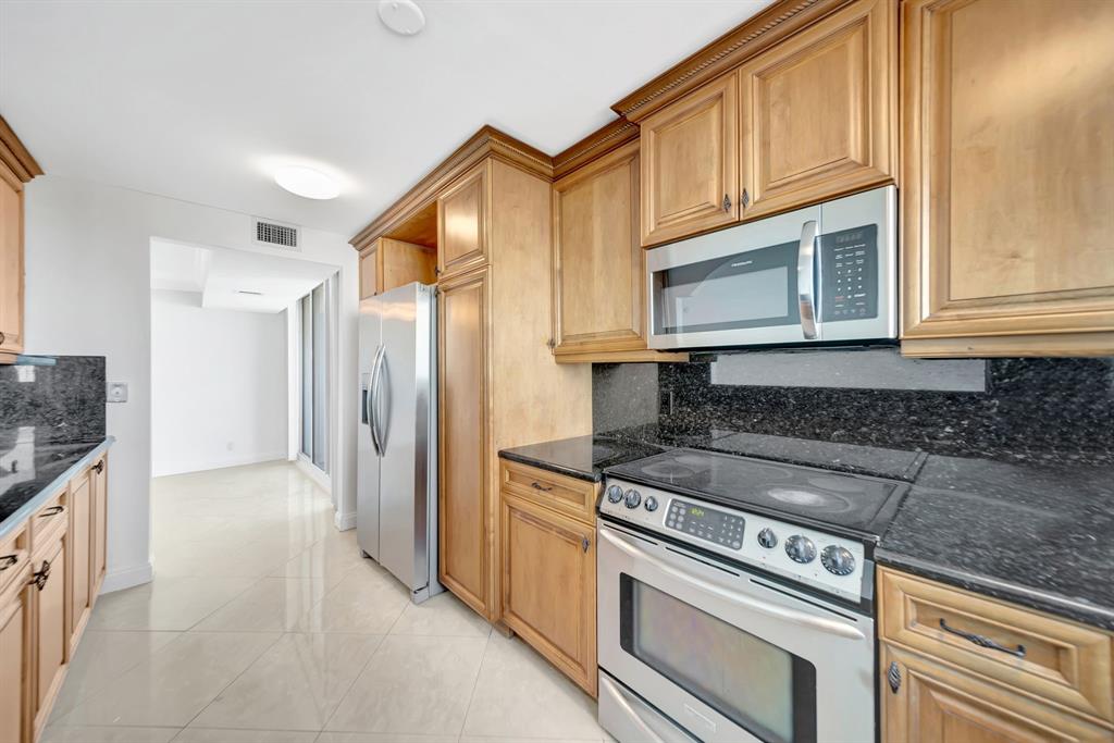 1360 South Ocean Boulevard, Unit 905 Pompano Beach, FL 33062 - Photo 13 of 57 a kitchen with stainless steel appliances granite countertop a stove microwave and refrigerator