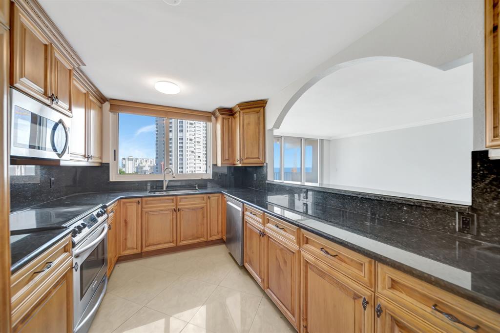 1360 South Ocean Boulevard, Unit 905 Pompano Beach, FL 33062 - Photo 14 of 57 a large kitchen with stainless steel appliances granite countertop a sink and a stove