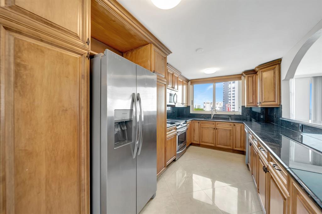 1360 South Ocean Boulevard, Unit 905 Pompano Beach, FL 33062 - Photo 15 of 57 a kitchen with stainless steel appliances granite countertop a refrigerator a sink dishwasher a oven with white cabinets and countertops