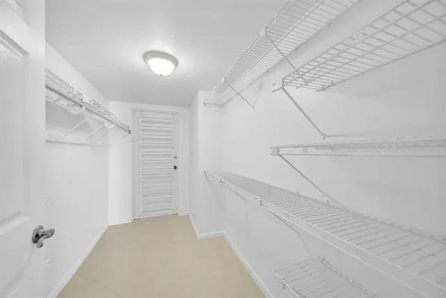 an empty room with windows and chandelier fan