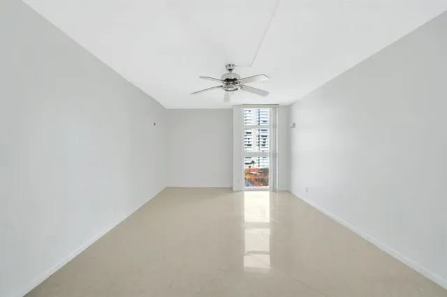 a view of an empty room with a chandelier fan