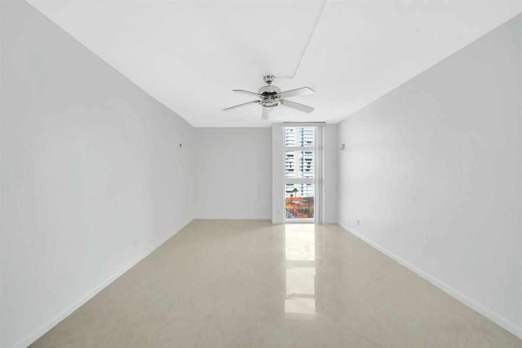 1360 South Ocean Boulevard, Unit 905 Pompano Beach, FL 33062 - Photo 28 of 57 an empty room with windows and chandelier fan