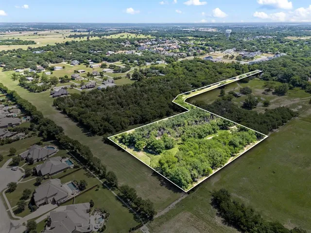 an aerial view of a residential houses covered in trees