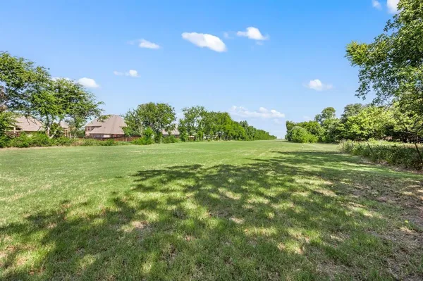 a view of a field with trees in the background
