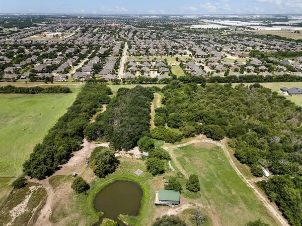 an aerial view of residential houses with outdoor space and trees