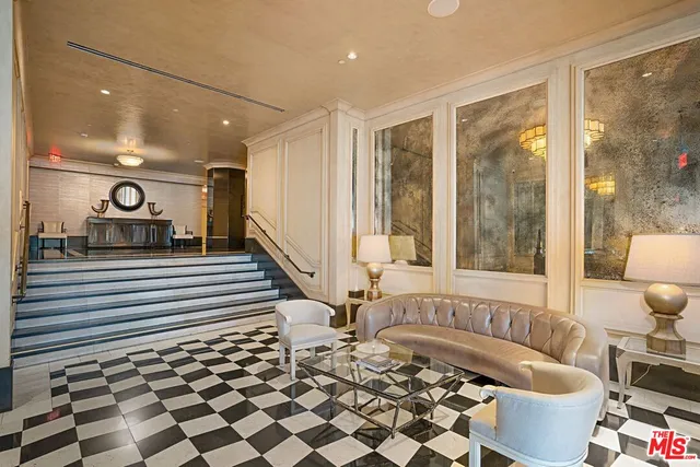 a living room with a black white checkered floor with a dining table and chair