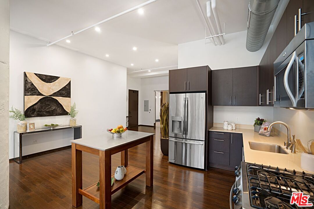 1645 Vine Street, Unit 703 Los Angeles, CA 90028 - Photo 11 of 44 a kitchen with stainless steel appliances granite countertop a refrigerator sink and stove