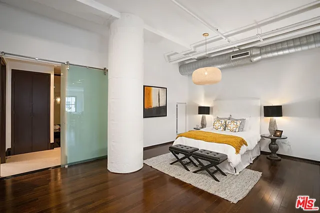 a bedroom with a bed and wooden floor